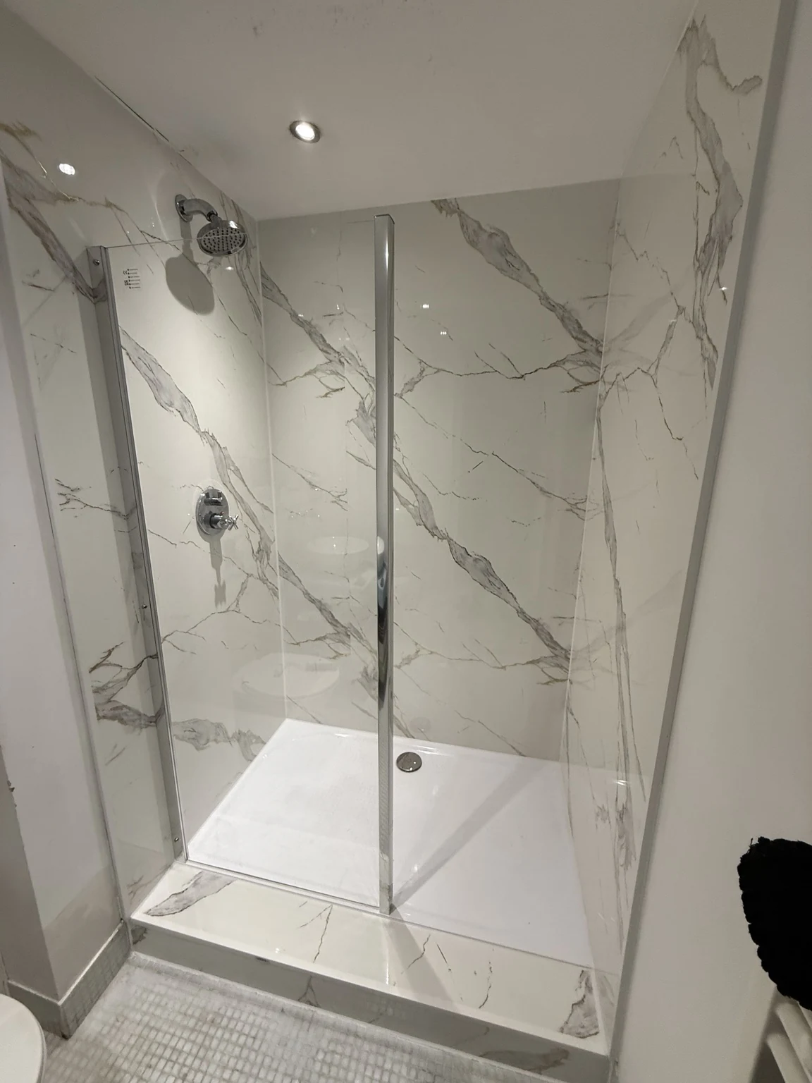 Shower after refurbishment with marble-effect panels